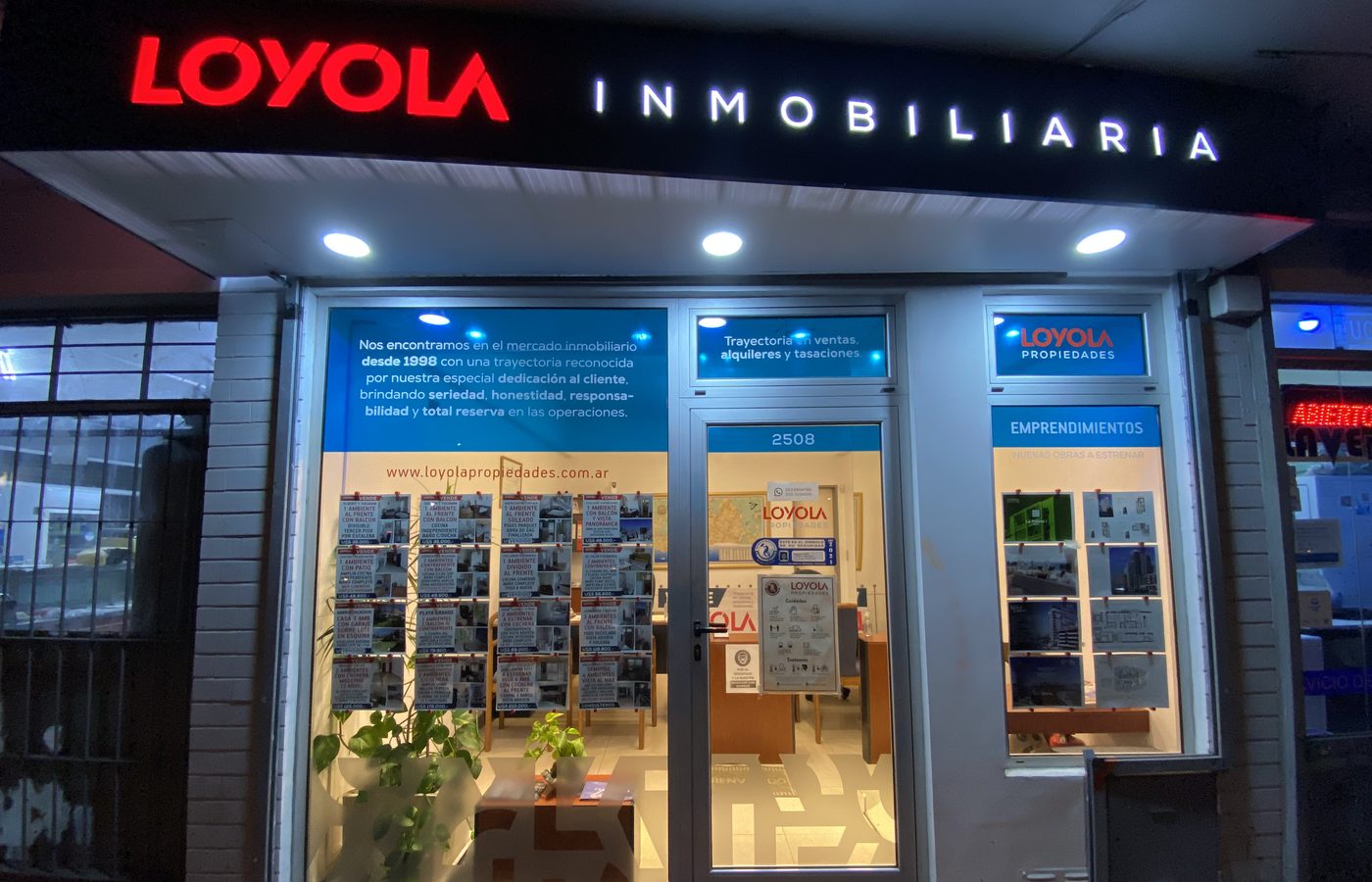 Frente de la inmobiliaria en Tucumán 2508 con el cartel de Loyola, de noche, en 2021