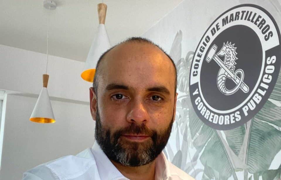 Mauro Musso frente al logo del Colegio de Martilleros y Corredores Públicos